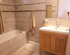 a bathroom with a tub and a sink and a bath tub at La Caz Anaïs avec jacuzzi in Saint-Joseph