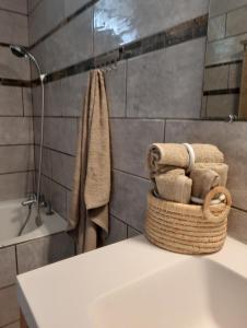 a bathroom with a basket of towels on a counter at La Caz Anaïs avec jacuzzi in Saint-Joseph