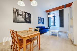 un soggiorno con tavolo e divano blu di Loft White by LookAp a Łódź