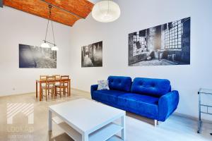 un soggiorno con divano blu e tavolo di Loft White by LookAp a Łódź