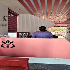 a man standing behind a counter in a restaurant at Hotel Rose Gold in Ahmadnagar