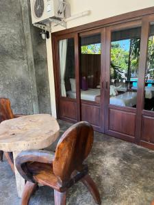einen Holztisch, einen Holzstuhl, einen Tisch und ein Zimmer in der Unterkunft Krabi Klong Muang Bay Resort in Klong Muang Beach