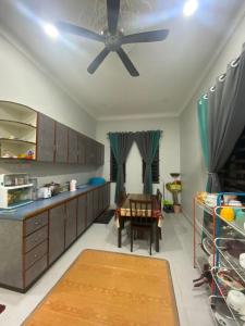 a kitchen with a ceiling fan and a table at RK ASIANA HOMESTAY, KEMAMAN in Cukai