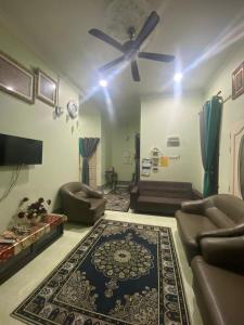 a living room with a ceiling fan and a rug at RK ASIANA HOMESTAY, KEMAMAN in Cukai