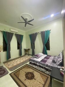 a bedroom with a bed and a ceiling fan at RK ASIANA HOMESTAY, KEMAMAN in Cukai