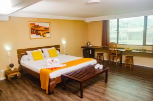 une chambre d'hôtel avec un lit, une table et des chaises dans l'établissement Hotel Le Pousse Pousse, à Antananarivo