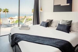 a bedroom with a large bed with a view of the ocean at Villa Macaronesia in Adeje