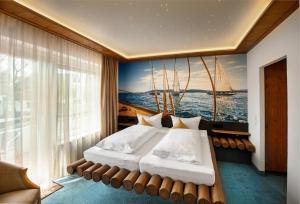 ein Schlafzimmer mit einem Bett mit einem Gemälde eines Segelboots in der Unterkunft Landgasthof Paradies in Frickingen