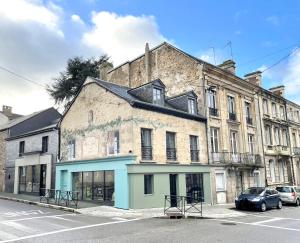 un vieux bâtiment au coin d'une rue dans l'établissement Bel appartement contemporain, à Aleçon