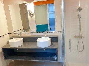 łazienka z 2 umywalkami i prysznicem w obiekcie Bel appartement contemporain w mieście Alençon