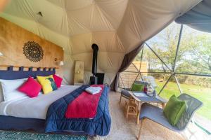 een slaapkamer in een tent met een bed en een tafel bij Le Nid du Tui in Faverolles