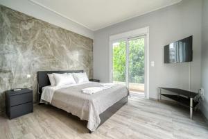 a bedroom with a bed and a tv on a wall at Charming Contemporary 2 bedroom apartment in Athens