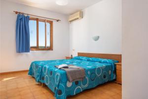 um quarto com uma cama com um cobertor azul em Holiday Park Santa Ponsa em Santa Ponsa