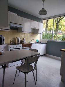 een keuken met een tafel en 2 stoelen. bij L'appart in Limoges