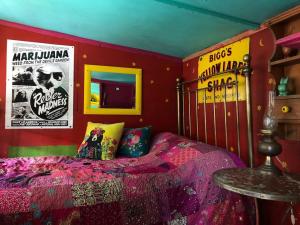 ein Schlafzimmer mit einem Bett und Plakaten an der Wand in der Unterkunft Surfers and walkers cosy camping cabin in Ilfracombe + 11 Fotos