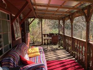 eine abgeschirmte Veranda mit einem Sofa und einem Tisch in der Unterkunft Surfers and walkers cosy camping cabin in Ilfracombe