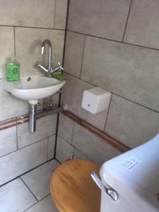 ein kleines Badezimmer mit Waschbecken und Toilette in der Unterkunft Surfers and walkers cosy camping cabin in Ilfracombe