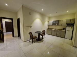 a kitchen with a table and chairs in a room at تـالـيـن الـهـفـوف in Al Hofuf