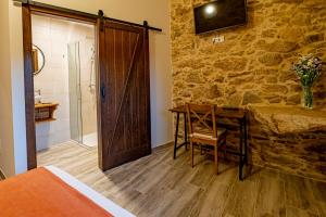 1 dormitorio con cama, escritorio y ducha en Casa Rural Laxido en Rianjo