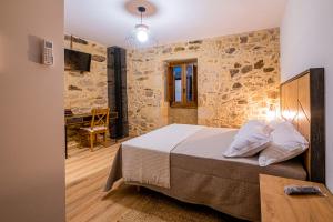 um quarto com uma cama com uma parede de pedra em Casa Rural Laxido em Rianjo