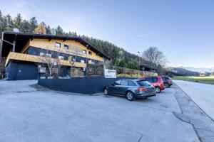 two cars parked in a parking lot in front of a building at The Art and Sporthotel in Innsbruck