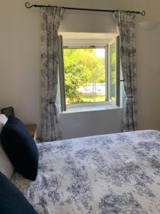 a bedroom with a bed and a window at La Sellerie at No 17 in Le Dorat
