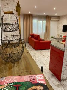 Apartamentos Sevilla Palace في إشبيلية: غرفة معيشة مع أريكة حمراء وطاولة