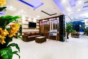 a lobby with a couch and a tv and plants at Hotel Pearl - Mahipalpur Delhi Airport in New Delhi