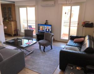 salon z kanapą i telewizorem w obiekcie 2 pièces 2 terrasses 100 m Croisette très clair. w Cannes