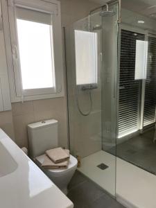 a bathroom with a toilet and a glass shower at Marbella Centre with terrace and pool in Marbella