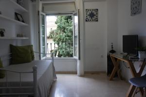 a room with a bed and a window and a desk at APN Rio Darro in Granada