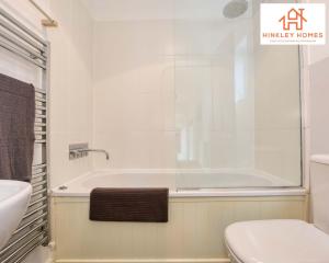 a bathroom with a tub and a toilet and a sink at Centrally Tucked Away Private 4bed - Free parking! By Hinkley Homes Short Lets & Serviced Accommodation in Bridgwater +34 photos