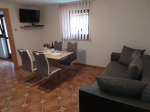 ein Wohnzimmer mit einem Sofa und einem Tisch mit Stühlen in der Unterkunft Apartmány Orava - Zuberec in Zuberec