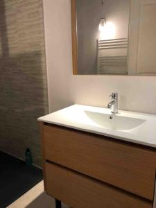 a bathroom with a white sink and a mirror at La Scellerie, le charme au cœur de Tours in Tours