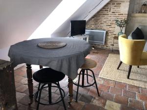 La Scellerie, le charme au cœur de Tours في تور: طاولة وكراسي في غرفة مع العلية