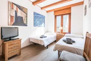 Riu Nere by SeaMount Rentals في فييا: غرفة بسريرين وتلفزيون بشاشة مسطحة