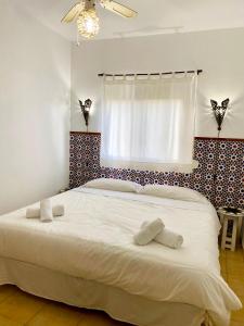 1 dormitorio con 1 cama blanca grande y ventana en Poniente, en Barbate
