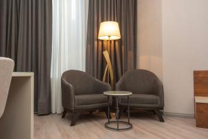 Dos sillas y una lámpara en una habitación de hotel. en Tbilisi Chambers, Trademark Collection by Wyndham, en Tiflis 75 fotos más