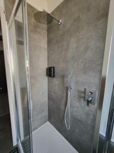 uma casa de banho com um chuveiro e uma porta de vidro em Santa Rita Suite em Turim