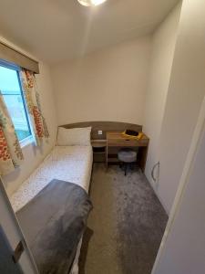 a small bedroom with a desk and a bed at Vault 21 in Millom