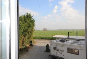an rv parked in a driveway next to a field at Camping De Grienduil in Nieuwland
