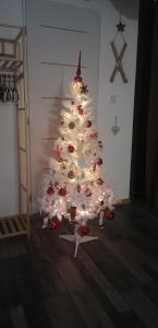 a white christmas tree with lights in a room at Gîte la source de la bruche in Bourg-Bruche