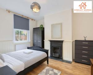 a bedroom with a bed and a fireplace at Centrally Tucked Away Private 4bed - Free parking! By Hinkley Homes Short Lets & Serviced Accommodation in Bridgwater