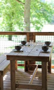 einem hölzernen Picknicktisch mit Schalen und Gläsern darauf in der Unterkunft Whaka Lodge in Seissan