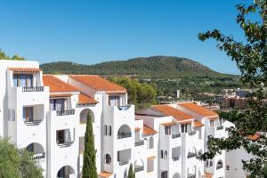 a view of a white building with a mountain in the background at Holiday Park Santa Ponsa in Santa Ponsa