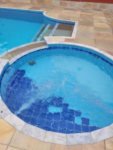 uma grande piscina com água azul num quintal em Apto Duplex com Mezanino em Juquei