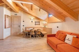 uma sala de estar com um sofá e uma mesa em Appartamento Family Engadina Chalet em Livigno