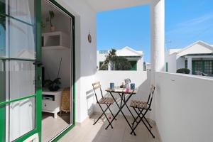 un pequeño balcón con mesa y sillas. en Casa Lorea, en Puerto del Carmen