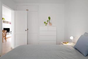 Un dormitorio blanco con una cama y armarios blancos. en Casa Lorea, en Puerto del Carmen