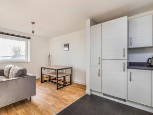 a kitchen with white cabinets and a table at Pass the Keys Central Modern Flat with Parking in Chichester